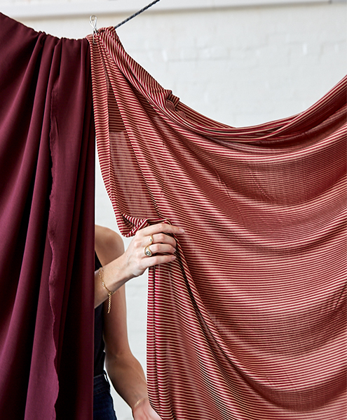 Draped Maroon and Red Stripe fabrics with a hand by Circular Sourcing